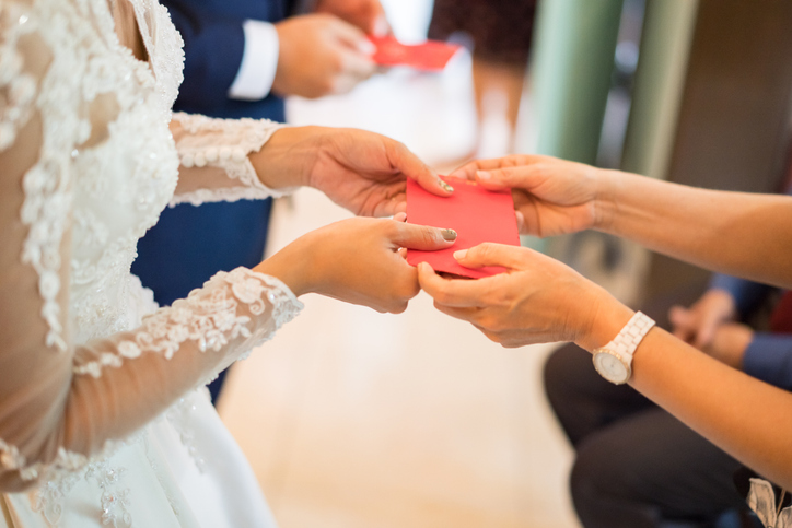 a red envelope being handed to a bride