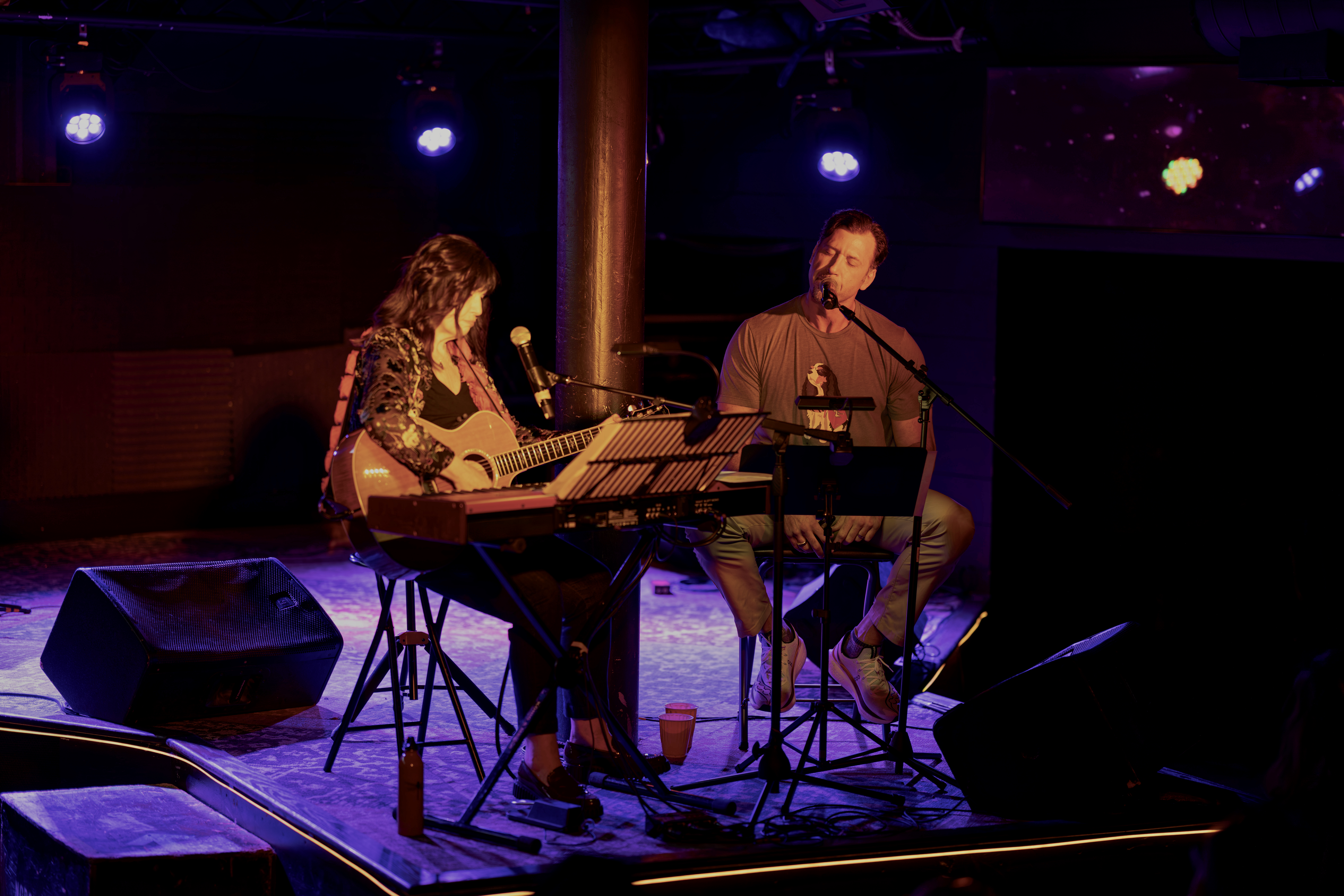 Seth Deutsch performs on stage accompanied by a guitarist
