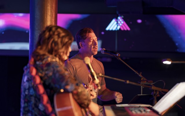 Seth singing with guitar accompaniment on stage