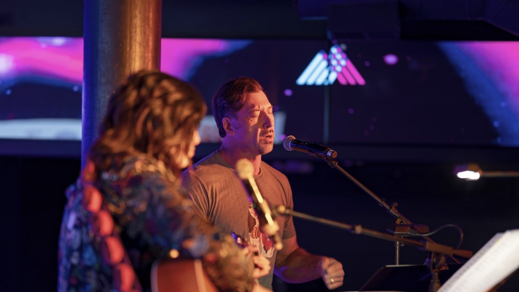 Seth singing with guitar accompaniment on stage